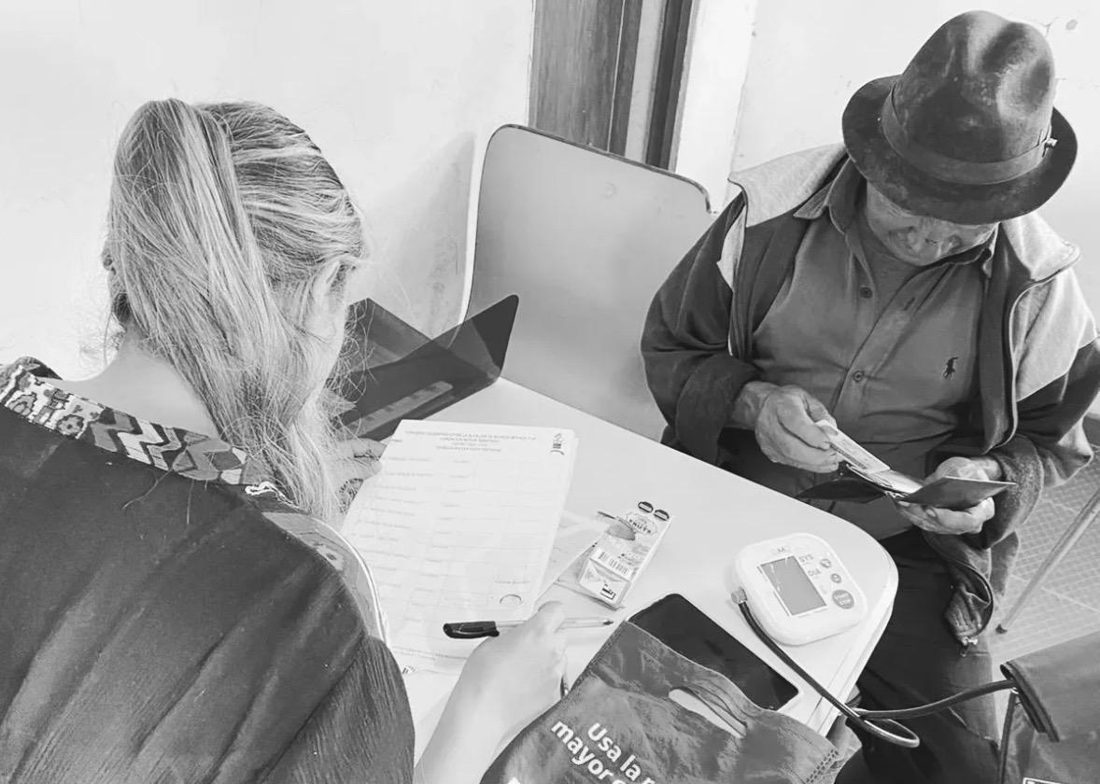 Paula Rojas atendiendo a un adulto mayor durante una jornada de salud